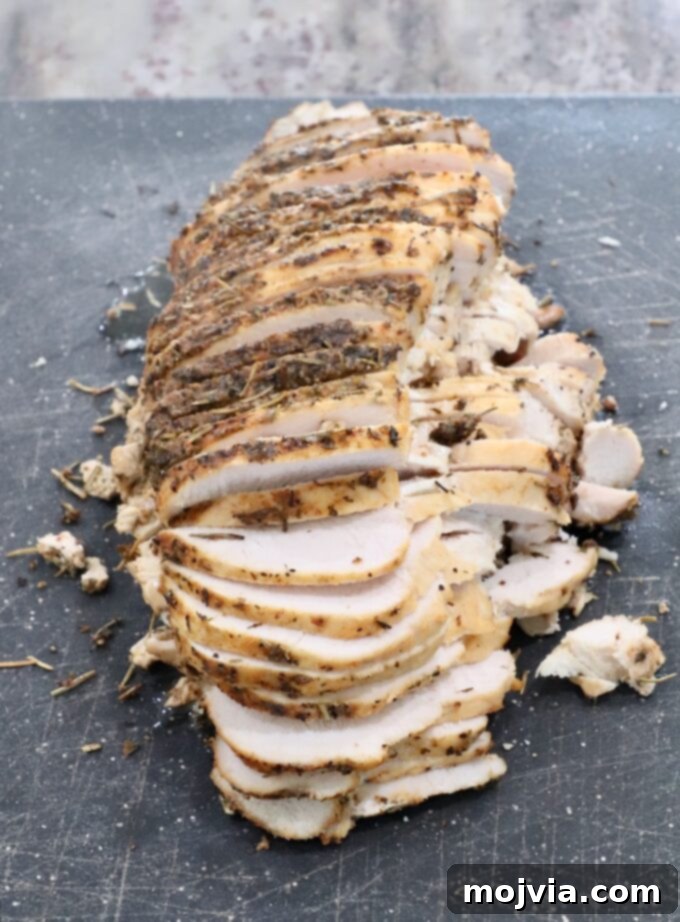 Melt-in-Your-Mouth Slow Cooker Turkey 9 A beautifully sliced turkey breast on a cutting board, showcasing its tender and moist interior.
