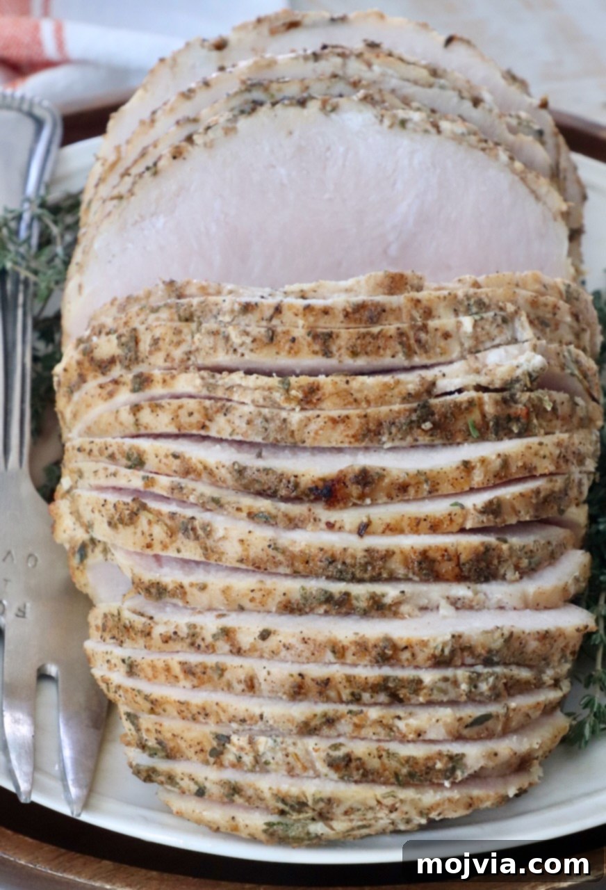 Beautifully sliced, juicy sous vide turkey breast perfectly arranged on a white plate, ready to be served.
