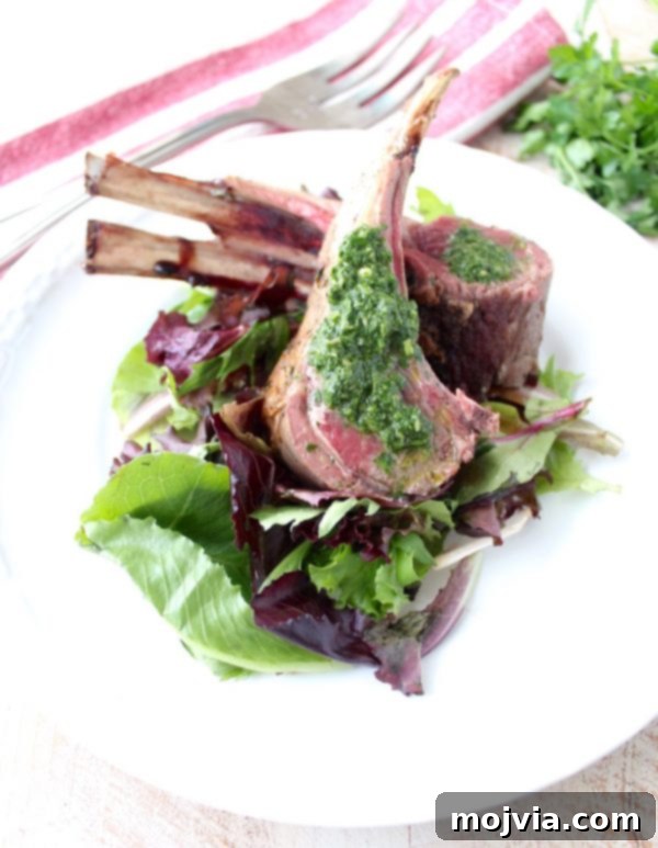 Succulent Herb Butter Roasted Lamb with Vibrant Mint Chimichurri 2 A perfectly roasted rack of lamb, generously coated in herb butter and drizzled with fresh mint chimichurri, ready to serve as an elegant dinner.