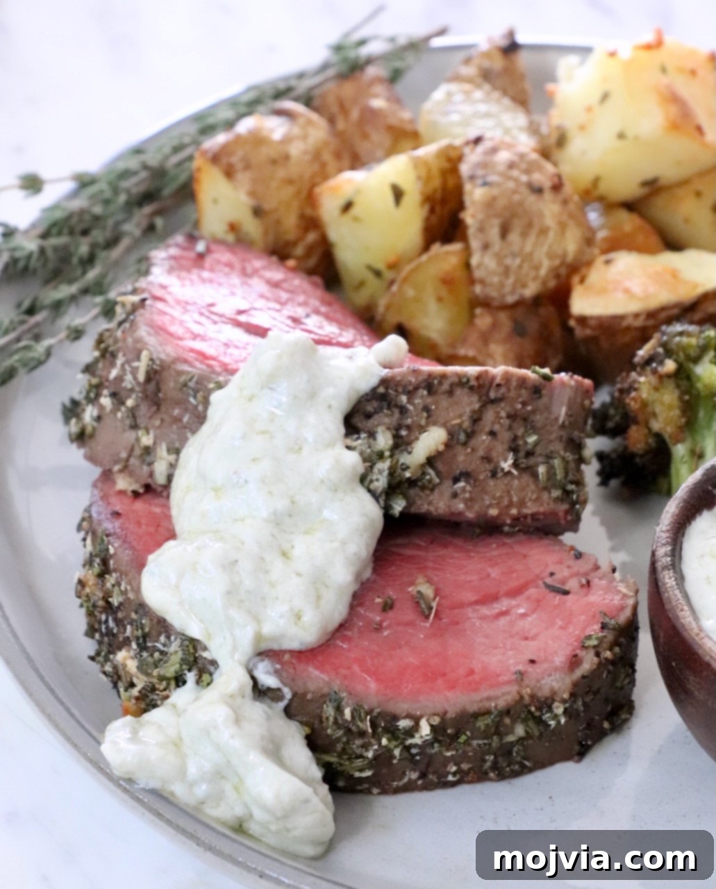 Slices of herb crusted beef tenderloin topped with gorgonzola cream sauce and served with roasted potatoes.
