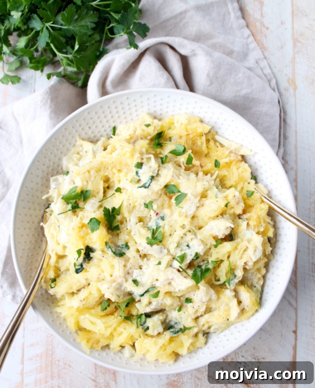Baked spaghetti squash is tossed with a simple spinach artichoke sauce in this healthy, gluten free and vegetarian recipe, made in under an hour!