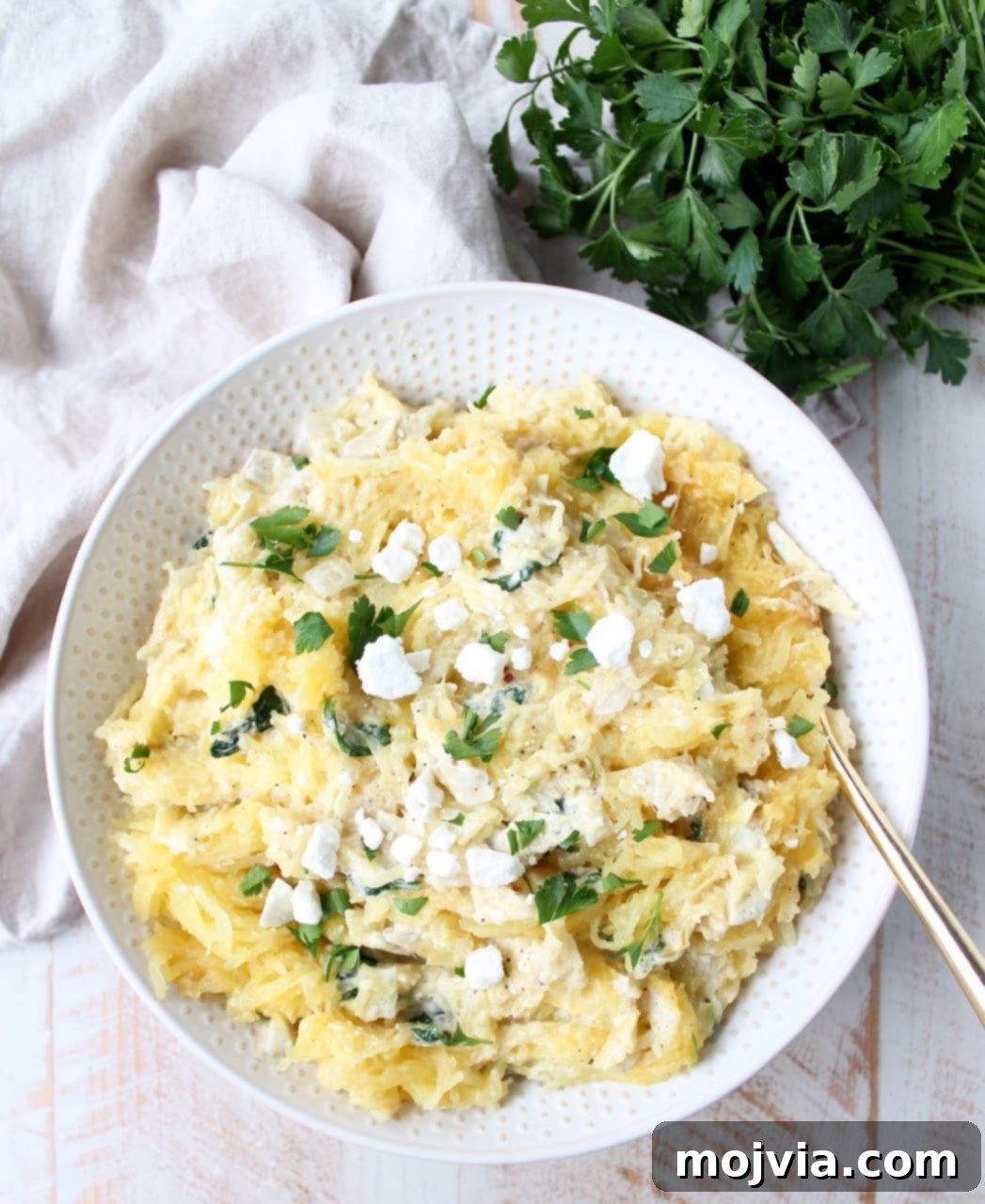 Baked spaghetti squash is tossed with a simple spinach artichoke sauce in this healthy, gluten free and vegetarian recipe, made in under an hour!