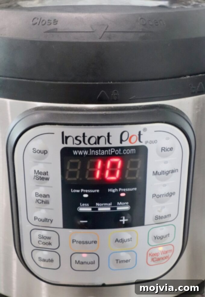 Spicy Shredded Instant Pot Buffalo Chicken 6 Instant Pot displaying a 10-minute timer for cooking chicken