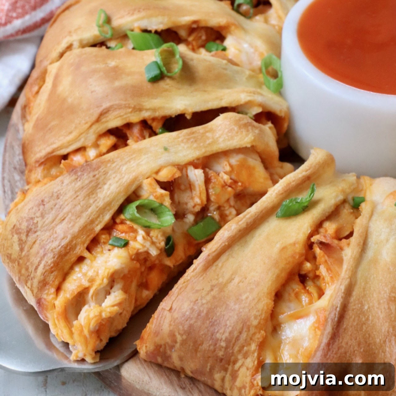 Spicy Shredded Instant Pot Buffalo Chicken 8 Buffalo chicken taco ring on a serving platter with diced green onions on top