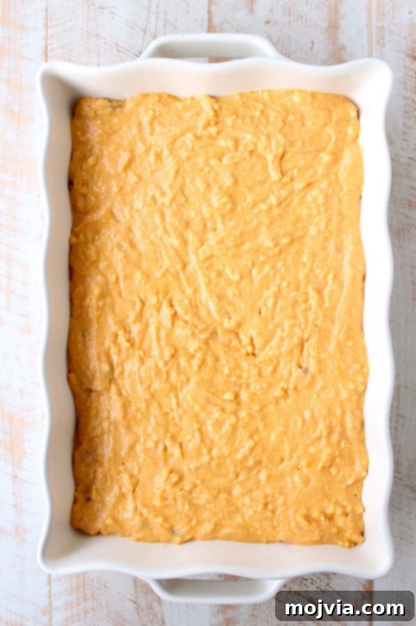 Cheesy Buffalo Chili Cornbread Bake 6 A layer of uncooked cornbread mix, studded with cheddar cheese, spread evenly over the chili in a casserole dish before baking.