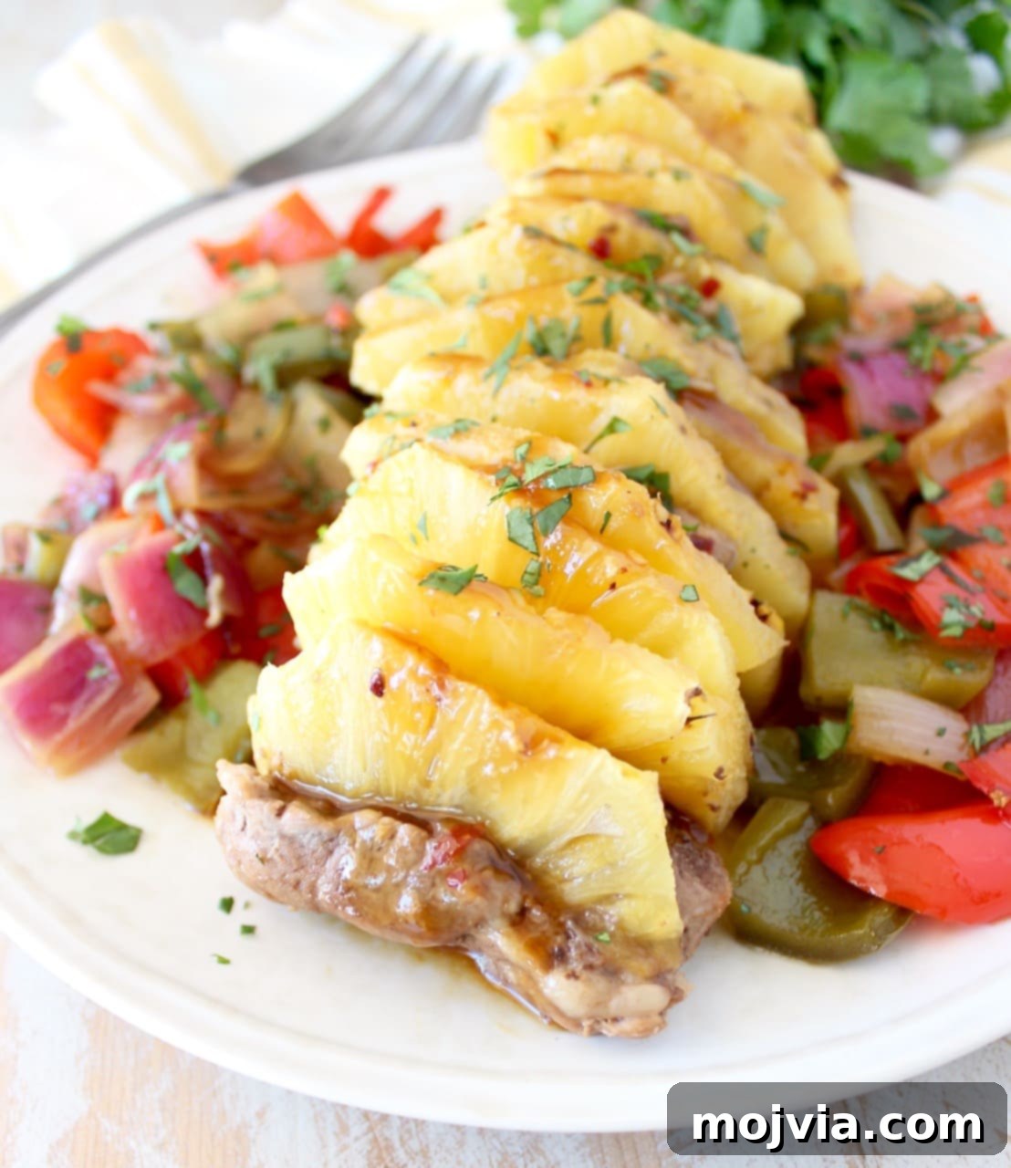 Sweet and Tangy Pineapple Teriyaki Pork Tenderloin 4 pork tenderloin filled with pineapple slices on a plate with vegetables