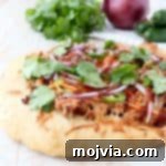 Turn your favorite banh mi sandwich into a pizza with this easy and delicious Banh Mi Pizza recipe, topped with sesame ginger ground pork, fresh carrots, jalapeños, cilantro and Sriracha!