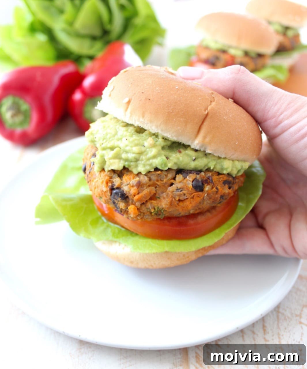 Quinoa, sweet potatoes, black beans & veggies are combined in this healthy, gluten free, black bean veggie burger recipe, which can be prepped ahead and stored in the refrigerator or freezer! Hand Holding Black Bean Veggie Burger