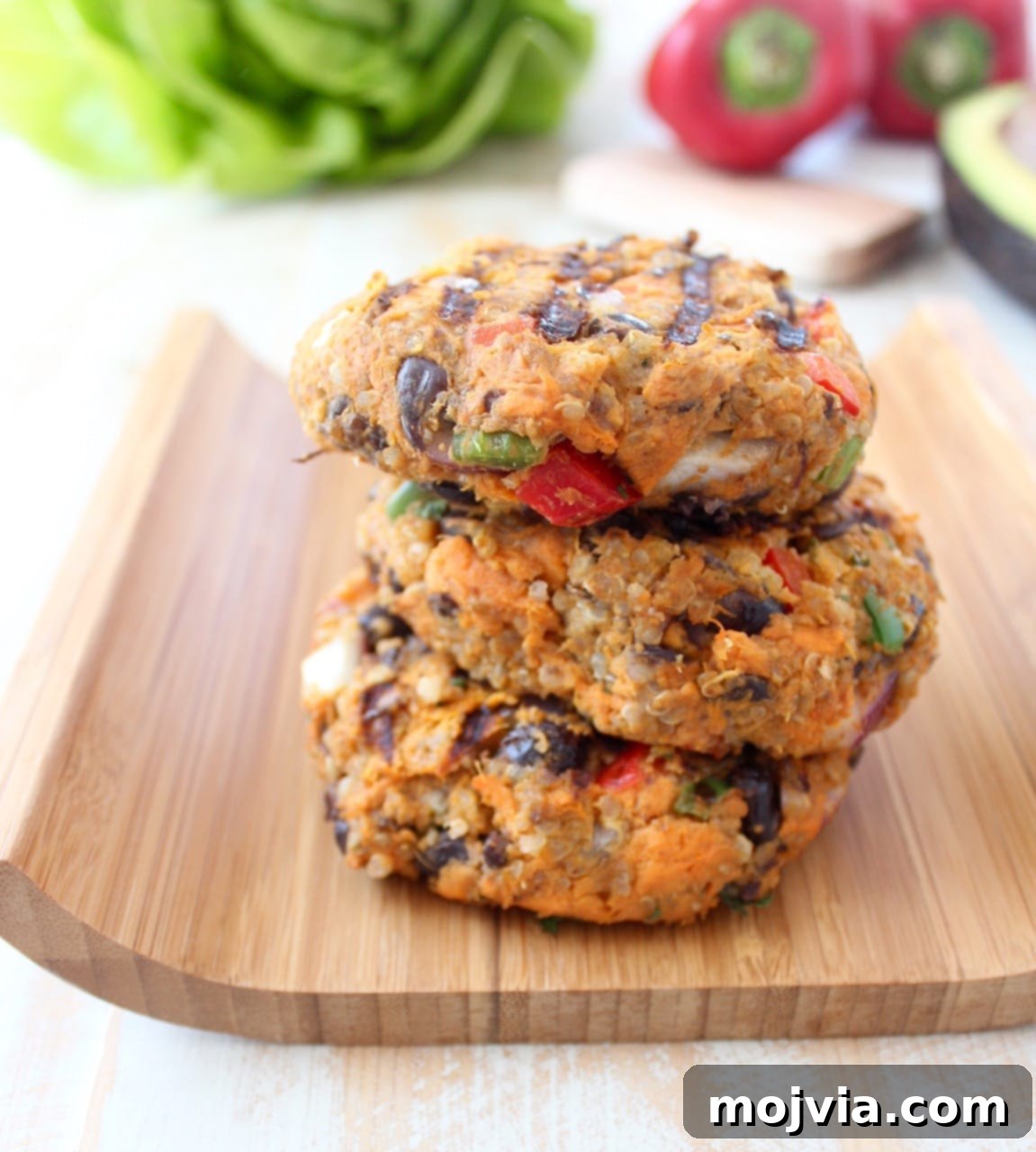 Quinoa, sweet potatoes, black beans & veggies are combined in this healthy, gluten free, black bean veggie burger recipe, which can be prepped ahead and stored in the refrigerator or freezer! Grilled Black Bean Veggie Burgers on a wood board