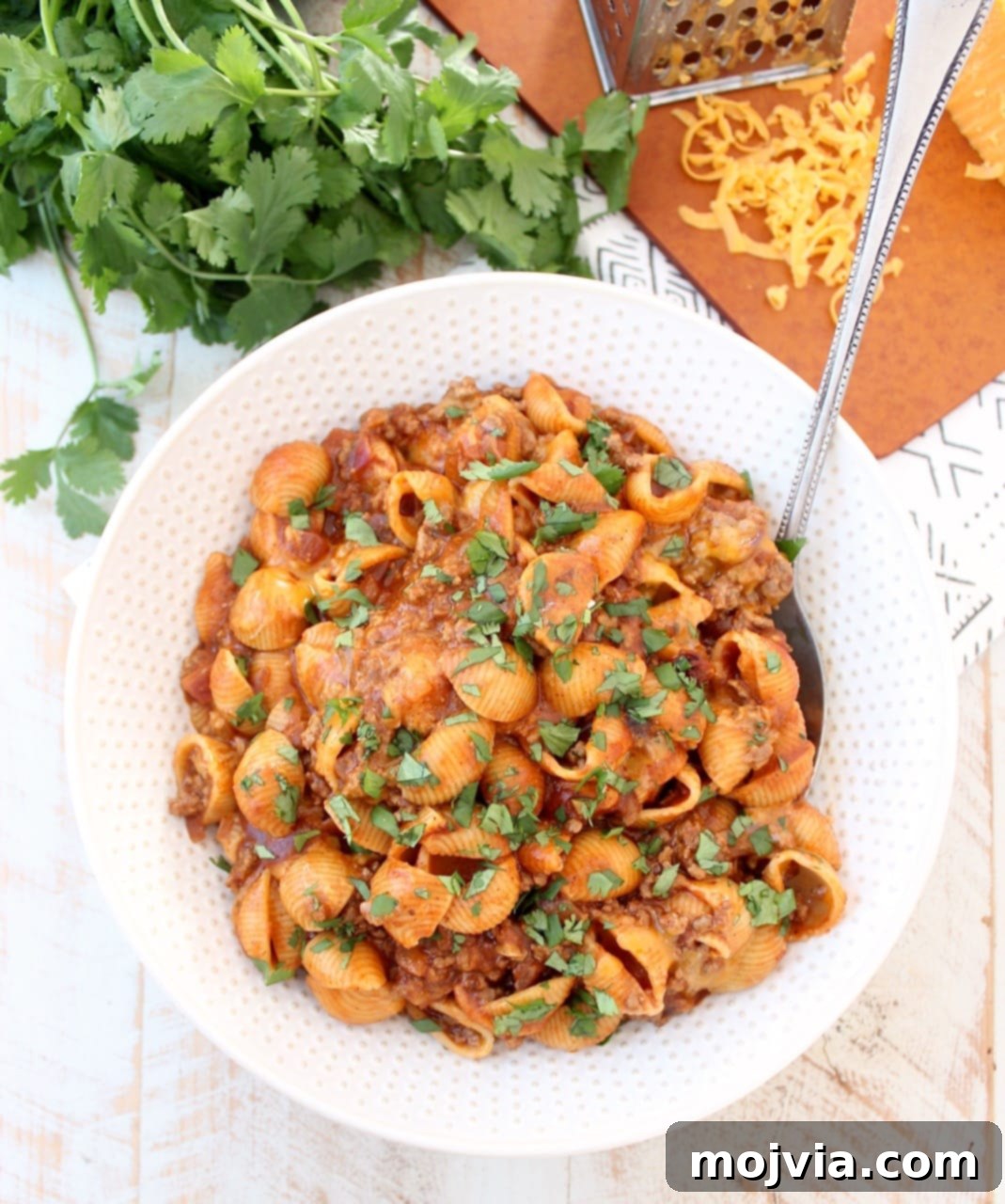 Overhead shot of Enchilada Pasta in a large serving bowl with a spoon, ready to be served