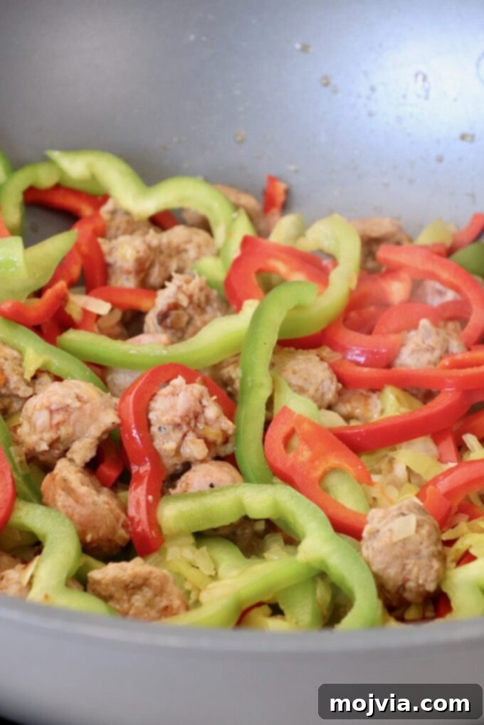 Boozy Italian Pasta 5 italian sausage and bell peppers cooking in pan