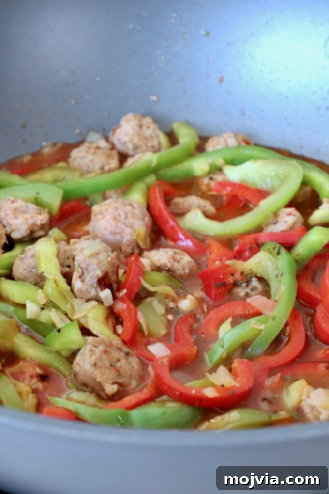 Boozy Italian Pasta 6 sliced bell peppers and Italian sausage in broth in large pan