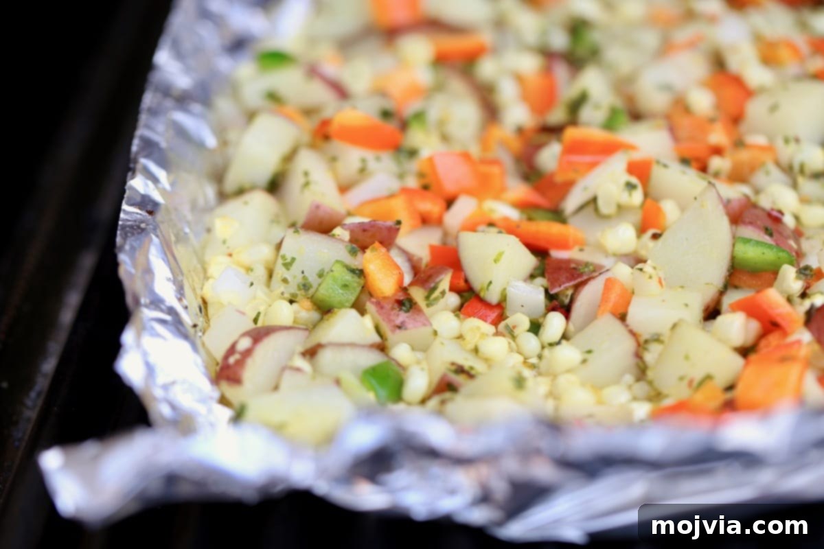 Diced Potatoes, bell peppers, onions, and garlic cooking in a foil basket on a hot grill, ready to become delicious taco filling.