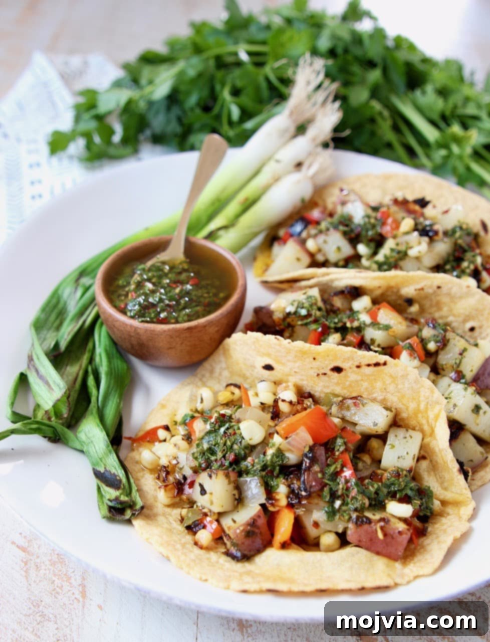 A plate of Vegan Tacos generously filled with a vibrant mix of grilled corn, tender potatoes, and colorful bell peppers, promising a delightful meal.