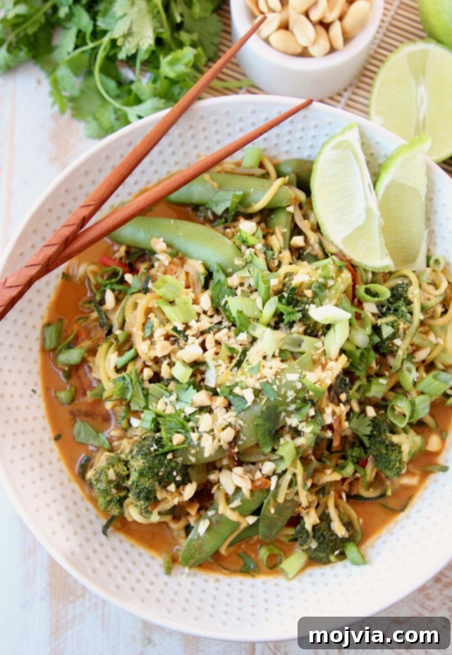Zucchini Noodle Pad Thai: A Fresh Vegan Spin 4 A delightful bowl of Vegan Pad Thai, beautifully garnished with fresh scallions, lime wedges, crisp broccoli, and cilantro, with chopsticks ready to dive in.