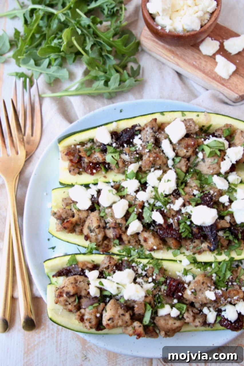 Zesty Greek Turkey Zucchini Boats 3 Overhead shot of cooked ground turkey stuffed in zucchini halves topped with crumbled feta cheese