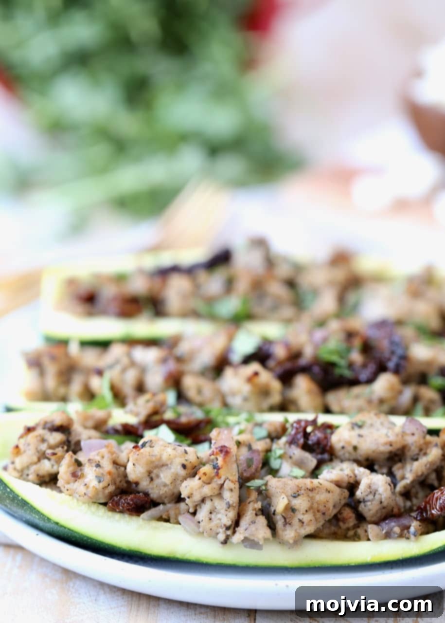 Zesty Greek Turkey Zucchini Boats 4 Ground Turkey and Sun Dried Tomatoes in zucchini boats on white plate