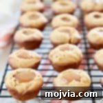 Mini Pumpkin Cookies filled with Salted Caramel on wire baking rack with orange striped towel