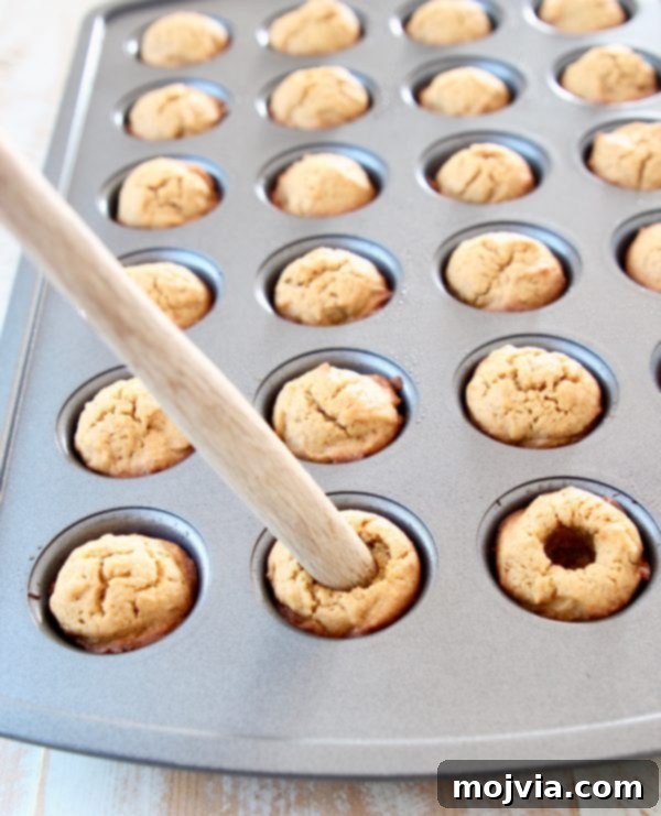 Using the end of a spatula to make pumpkin cookie cups in mini muffin tin