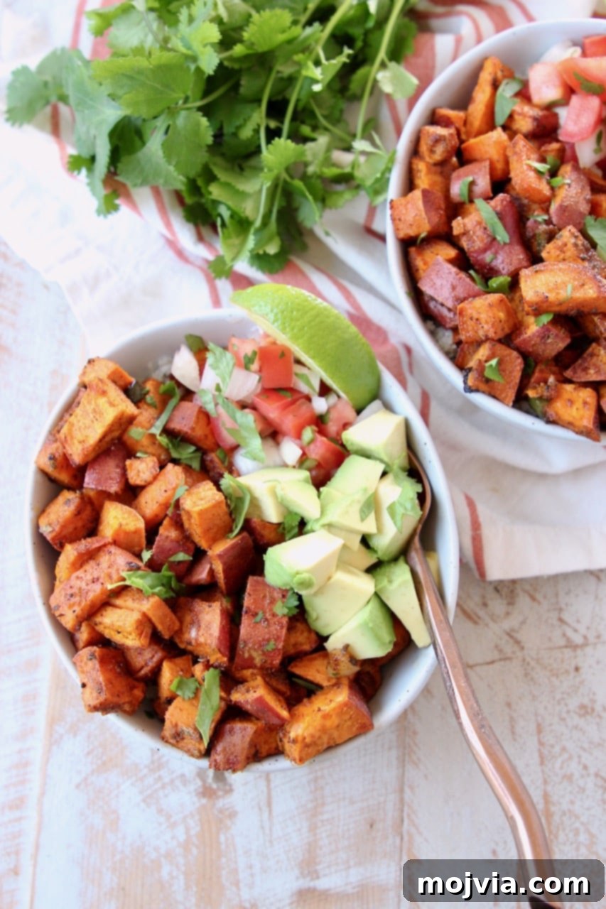 Southwest Vegan Sweet Potato Quinoa Fiesta 4 Overhead shot of diced sweet potatoes in bowl with quinoa, diced avocado, pico de gallo, lime wedge, cilantro and copper fork