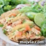 Pressure cooker chicken tacos in corn tortillas on white plate with cilantro and limes