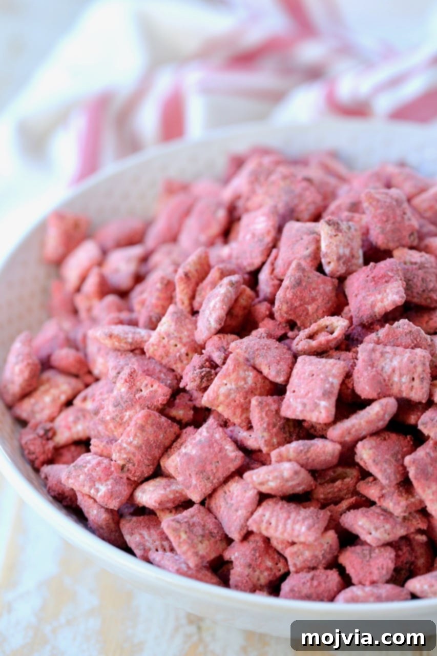 Crimson Velvet Crunch 2 Red velvet puppy chow in white bowl with red and white striped towel, highlighting the vibrant red color