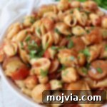 Cooked pasta, sausage, and peppers in spicy cajun tomato sauce in a bowl, ready to serve.