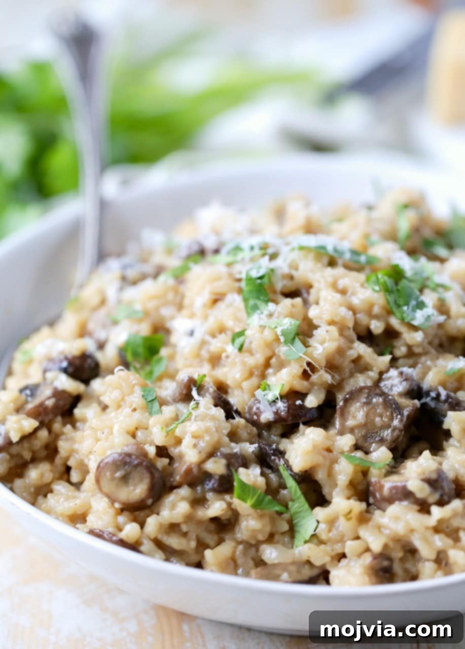 Velvety Instant Pot Mushroom Delight 2 A bowl of creamy Instant Pot mushroom risotto garnished with fresh parsley and grated Parmesan cheese, with a large serving spoon.
