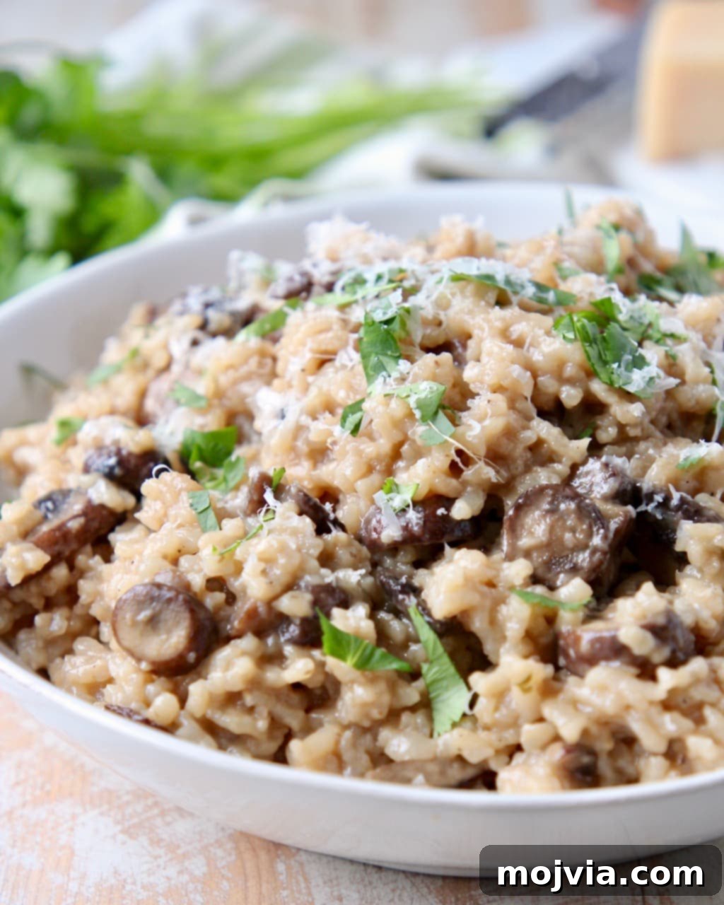 Velvety Instant Pot Mushroom Delight 3 Close-up of Instant Pot mushroom risotto in a white bowl, garnished with fresh parsley and a sprinkle of Parmesan cheese, ready to be served.