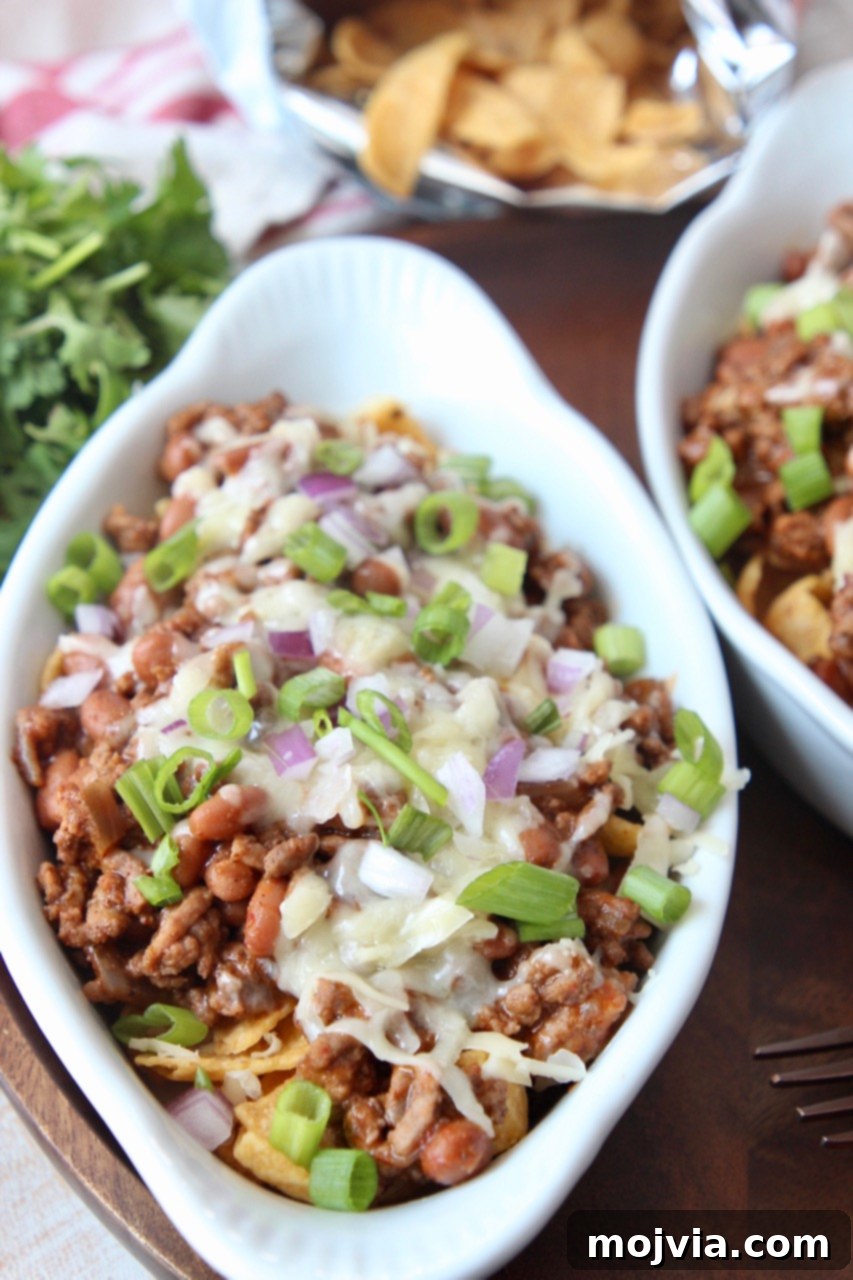 Tex-Mex Chili Crunch 6 A large white serving dish filled with Frito Chili Pie, ready to be served