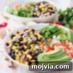 Plant-Powered Burrito Bliss 5 White bowl with sliced avocado, black bean and corn relish, diced tomatoes and shredded lettuce
