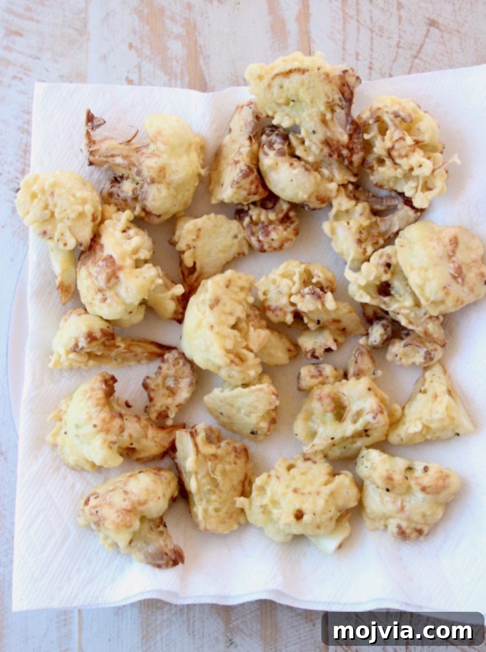 Gochujang Glazed Cauliflower Wings 4 Fried cauliflower pieces on paper towel lined plate