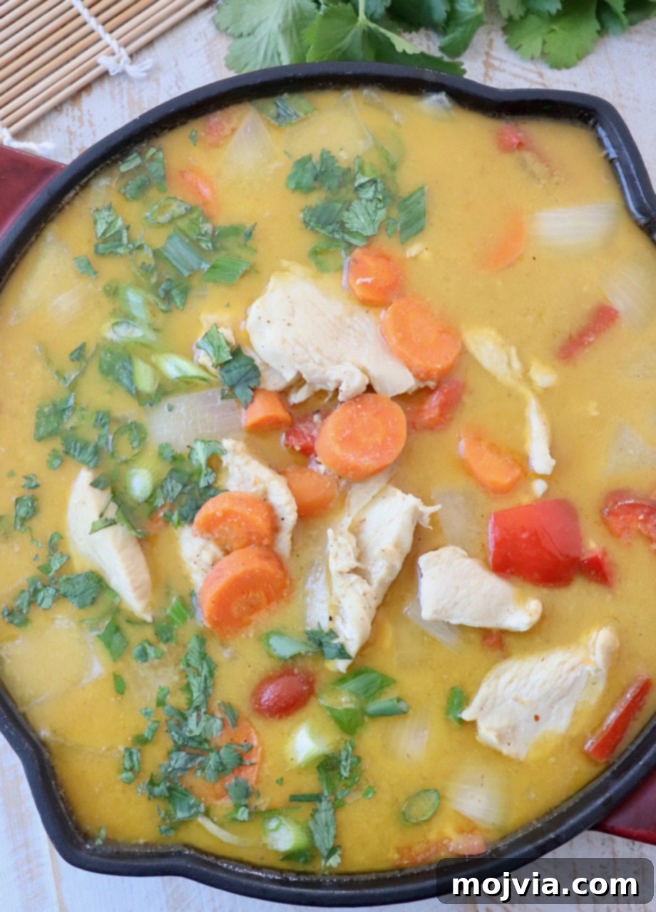 chicken and vegetables in yellow curry sauce in skillet