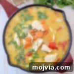 chicken and vegetables in yellow curry sauce in skillet