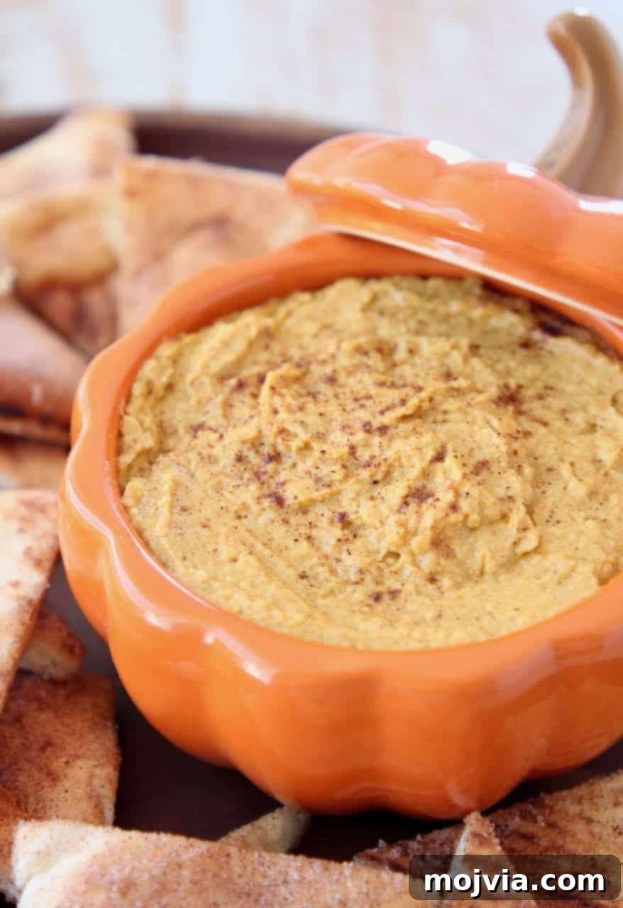 Pumpkin hummus in orange pumpkin serving bowl