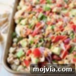 Nacho Florets 5 Cauliflower nachos on gold sheet pan topped with diced tomatoes and avocado