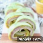 Pinwheel sandwiches with spinach tortillas, ham, cheese, pickles and mustard inside