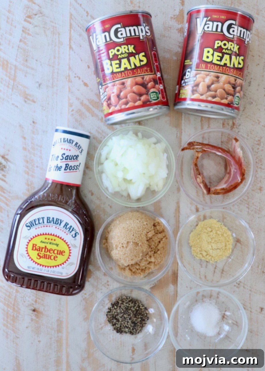 Dad's Legendary BBQ Baked Beans 3 A rustic spread of fresh ingredients for BBQ baked beans, including cans of beans, bacon, brown sugar, onions, and spices, arranged on a white wooden board.