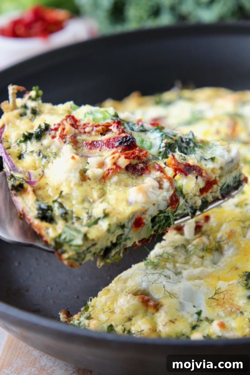 Sun-Kissed Mediterranean Frittata 2 Slice of vibrant vegetable frittata lifted out of skillet with a spatula, showcasing its wholesome ingredients.