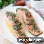 Two pieces of salmon on plate topped with chimichurri sauce