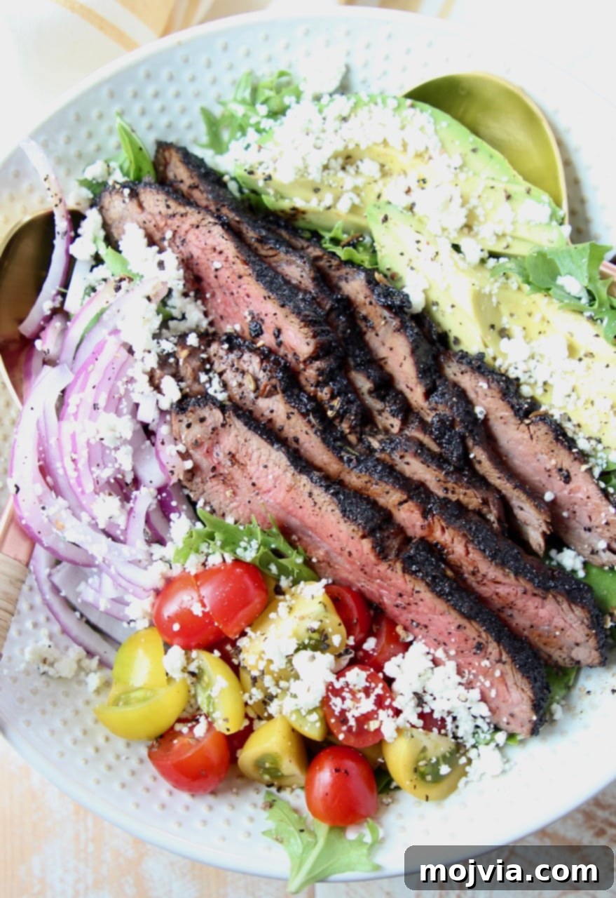 Steak salad in bowl with tomatoes, avocado and onions