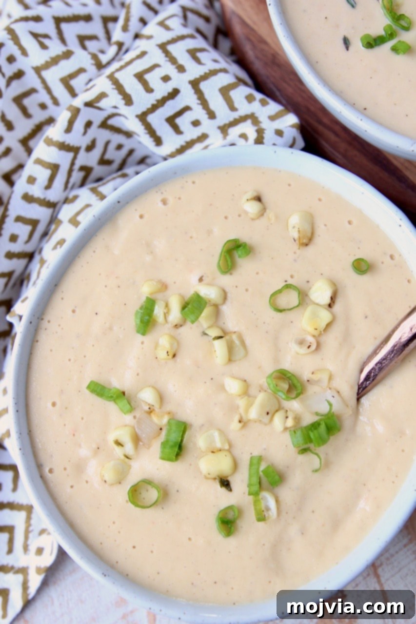 Golden Creamed Corn Soup 2 Creamy corn soup in bowl with corn kernels and green onions on top