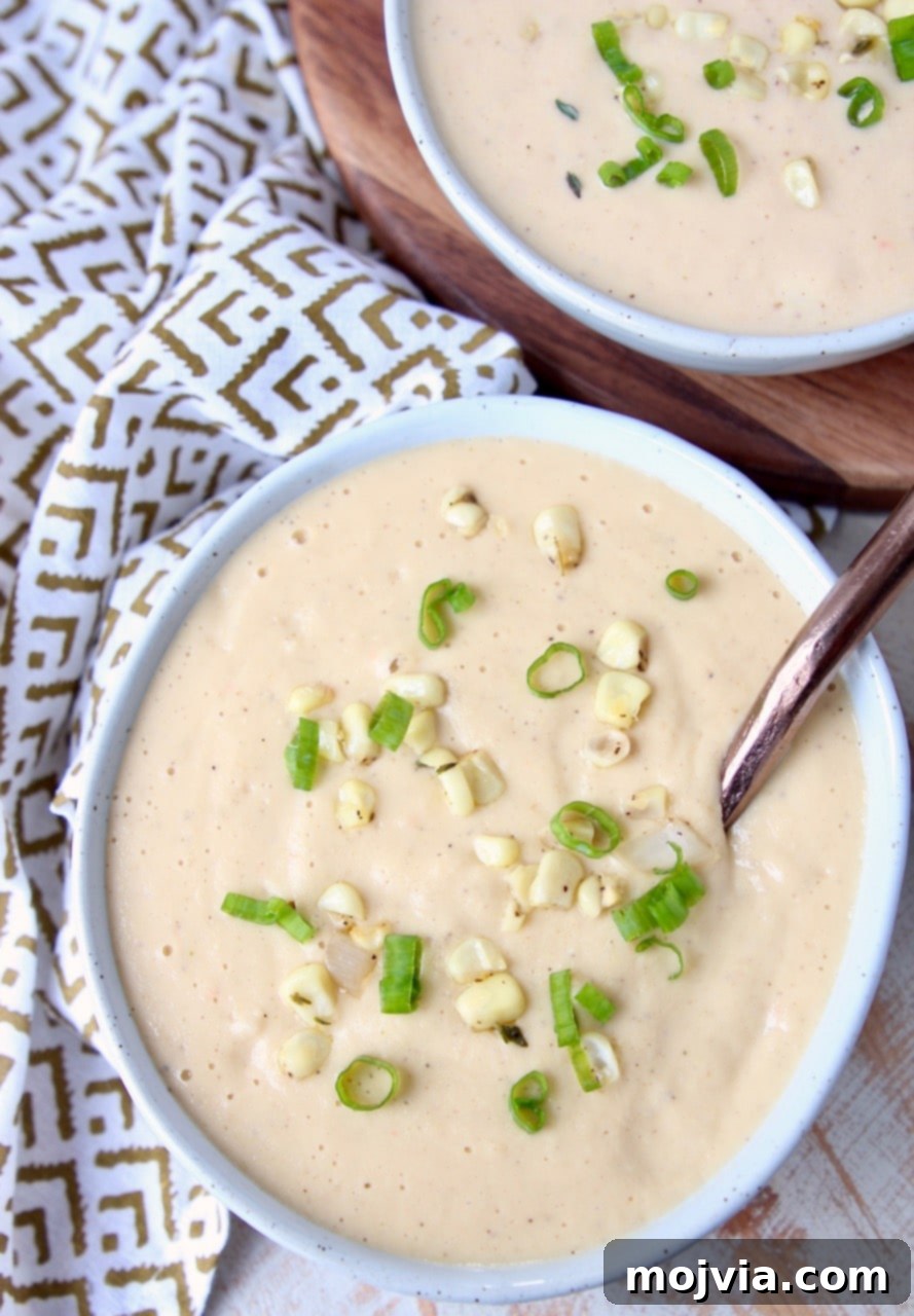 Golden Creamed Corn Soup 5 Creamy corn soup in bowl with copper spoon