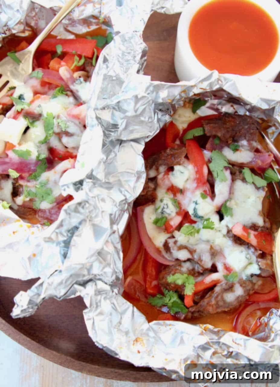 Steak, peppers, onions and melted cheese in foil pack