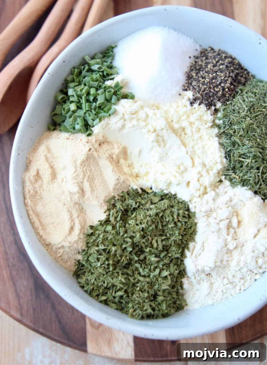 Ultimate Homemade Ranch Spice Blend 5 Ranch seasoning mix ingredients separated in white bowl on wood cutting board