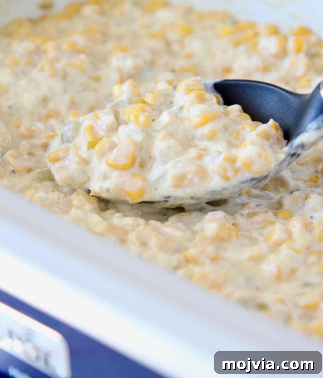 Velvety Slow Cooker Creamed Corn 3 Creamed corn in crock pot with serving spoon, ready to be served