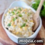 Velvety Slow Cooker Creamed Corn 6 Creamed corn in white oval serving dish with wooden spoon