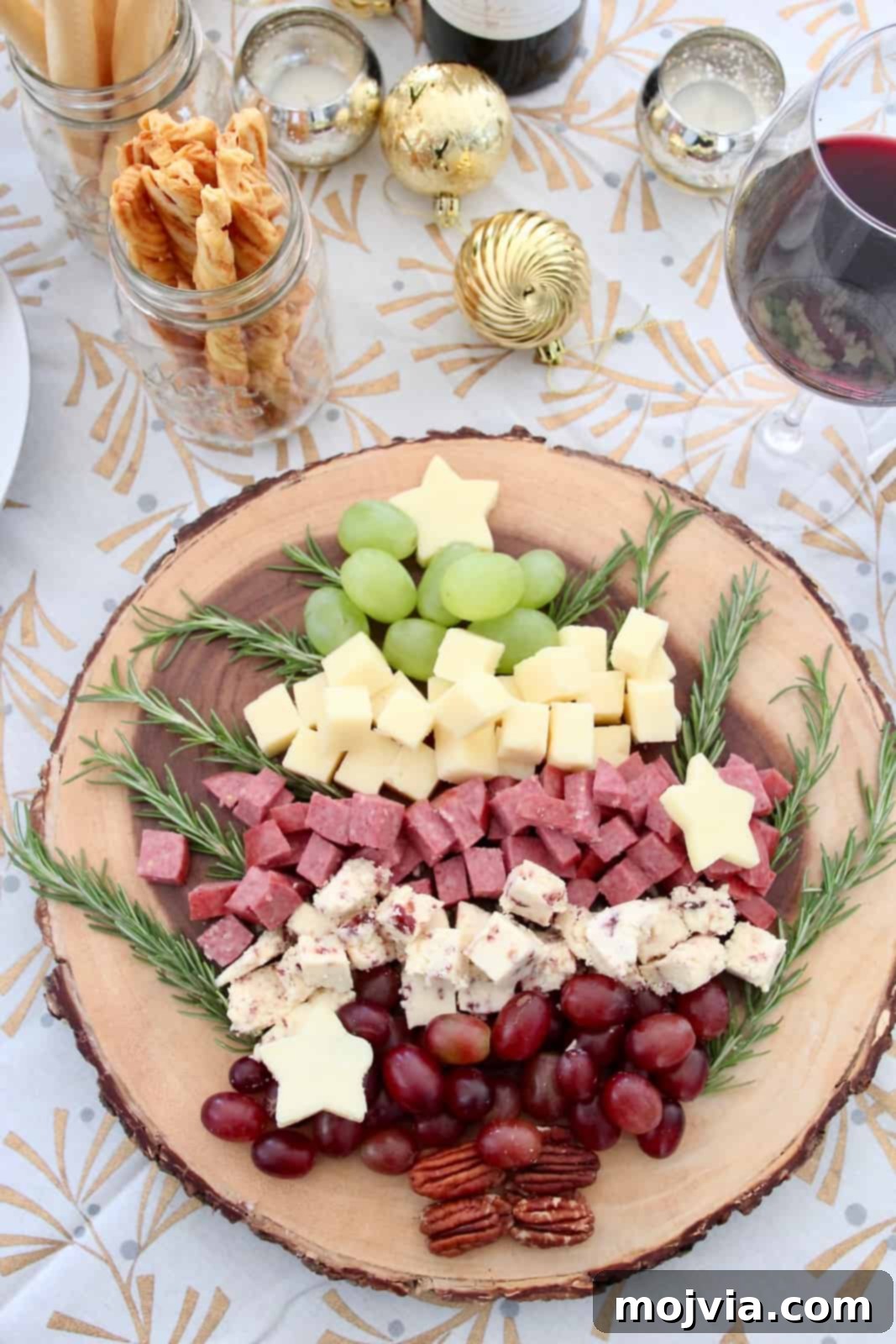 Yuletide Evergreen Cheese Board 2 A beautifully arranged Christmas tree shaped holiday cheese board, featuring various cheeses, meats, grapes, and garnishes, set for festive entertaining.