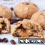Oatmeal raisin cookie cut in half with caramel coming out of the center
