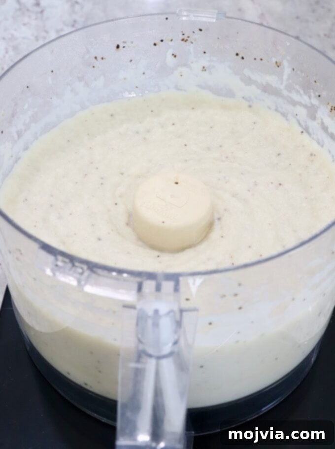 Creamy Cauliflower Mash 6 Smooth and creamy pureed cauliflower inside a food processor, ready to be seasoned and served.